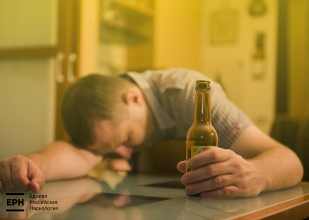 Мужчина уснул на столе с бутылкой в руке